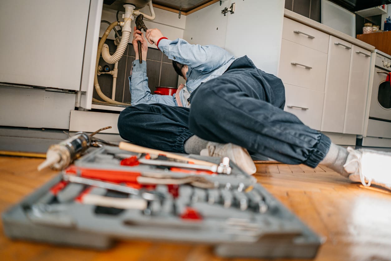 Plumber Working Under Sink